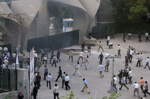 Membros da milícia Basij atiram pedras aos manifestantes que estão dentro da Universidade de Teerão a 14 de Junho de 2009