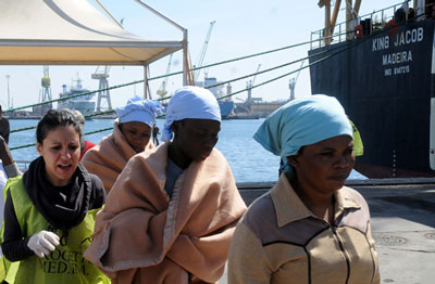 Migrantes do Norte de África recolhidos de um barco virado no Mediterrâneo chegam a Itália a 13 de April de 2015
