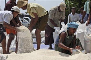Trabalhadores enchem sacos com arroz