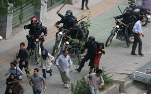 Manifestantes perseguidos por milicianos com bastões, frente à Universidade de Teerão, 14 Junho
