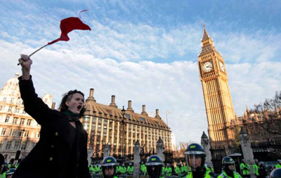 Estudante com uma bandeira vermelha protesta na Praça do Parlamento