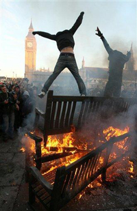 Manifestantes saltam por cima do fogo na Praça do Parlamento
