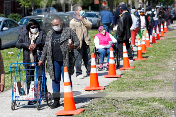 Pessoas de diversos setores sociais numa fila de distribuição de alimentos num bairro de Chicago a 12 de maio. (Foto: AP)