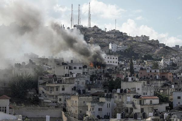 Fogo e fumo resultantes da ocupação israelita de Jenin, Cisjordânia, 13 de dezembro de 2023