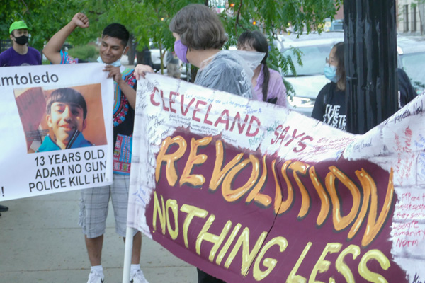 Os cartazes dizem: “REVOLUÇÃO, E NADA MENOS!” e “Adam Toledo, 13 anos, não tinha uma arma, a polícia matou-o”